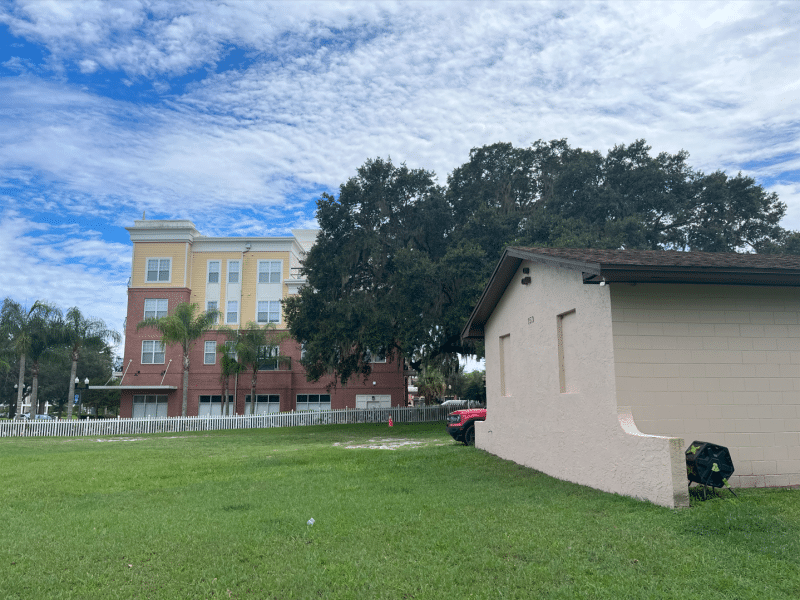 An image of the Kingsbury house with the four-story buildings of the Winter Springs Town Center in the background.