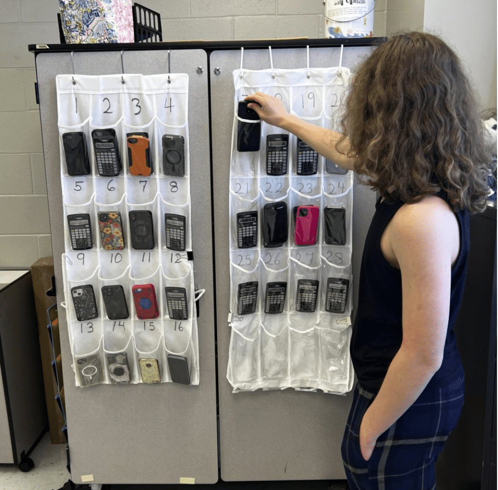 Sophomore Jasper Thompson puts his phone in his assigned pocket in Mrs. Grasso’s room.