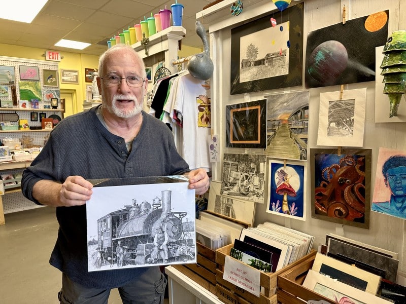 Artist Robert Score shows one of his drawings at The Roost, in Oviedo.